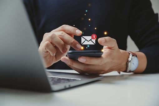 A phone in people's hands. With the mail icon appearing